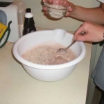 Jenni adds the malted milk ball bits. Emily stirs.