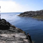 Down a treacherous winding staircase cut into the cliff, I find a metal ladder into the sea