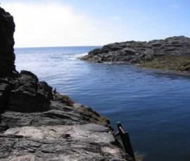Down a treacherous winding staircase cut into the cliff, I find a metal ladder into the sea Down a treacherous winding staircase cut into the cliff, I find a metal ladder into the sea