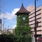 An ivy covered clock tower at Maders