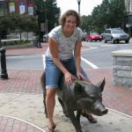 Jenni rides a pig.