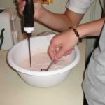 Jenni adds the chocolate syrup. Emily stirs.