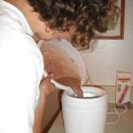 Emily finishes stirring and Jenni adds the mixture to the maker.